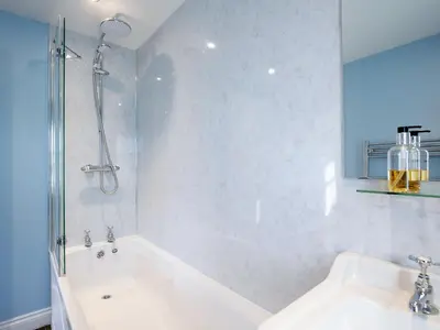 a bathroom with a tub and a shower and a sink at Nettlebush Cottage-Uk5629 in Drummelzier