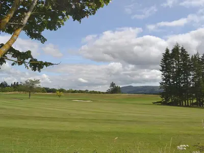 a view of a golf course with a green at Rossie Cottage in Auchterarder