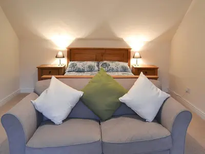 a couch with three pillows on it in a bedroom at Riverside in Kilmelford