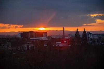 a city skyline with the sun setting in the background at Glasgow Youth Hostel in Glasgow