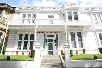 a white house with the entrance to the marsh antlers at Embassy Apartments in Glasgow