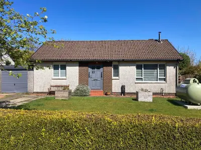 a house with a yard with a bench and a house at Achnaha in Ardentinny