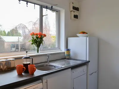 a kitchen with a sink and a refrigerator and a window at Achnaha in Ardentinny
