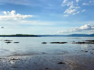 a large body of water with rocks in it at Largs Brisbane Cottage in Largs
