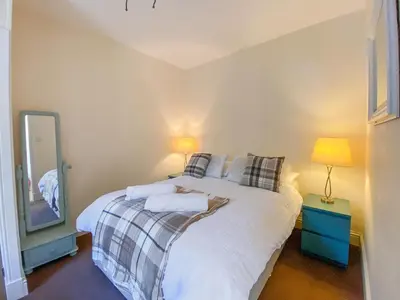 a bedroom with a white bed with a mirror at Largs Brisbane Cottage in Largs