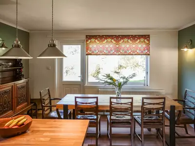 a dining room with a table and chairs and a window at Strathcashel Cottage in Rowardennan