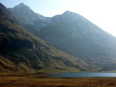 a mountain with a lake in front of it at Glencoe Youth Hostel in Ballachulish