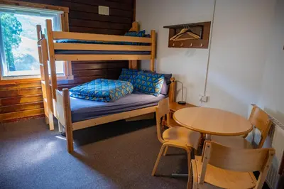 a small room with a bunk bed and a table at Glencoe Youth Hostel in Ballachulish