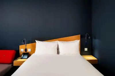 a bedroom with a large white bed and a red couch at Holiday Inn Express Hamilton by IHG in Hamilton