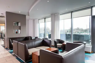 a waiting room with leather furniture and large windows at Holiday Inn Express Hamilton by IHG in Hamilton