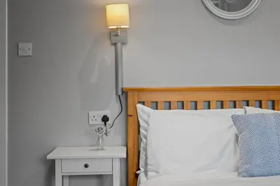 a bedroom with a bed with a lamp on a table at Queensferry Guest house in Rosyth