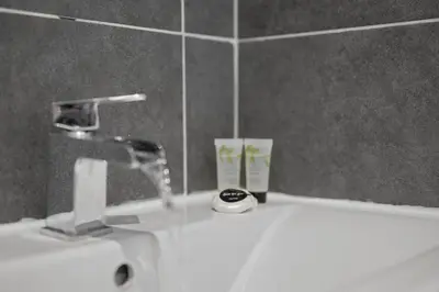 a bathroom sink with a faucet and a mirror at Queensferry Guest house in Rosyth