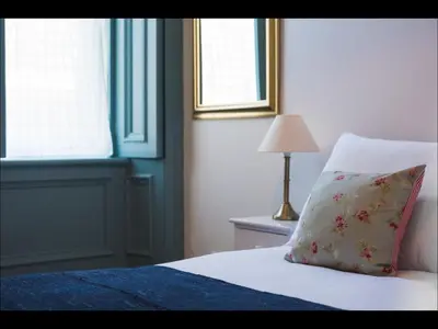 a bedroom with a bed with a pillow and a lamp at Cedar Apartment in Helensburgh