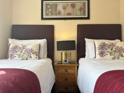 a bedroom with two beds and a lamp on a night stand at Beaches in Ayr