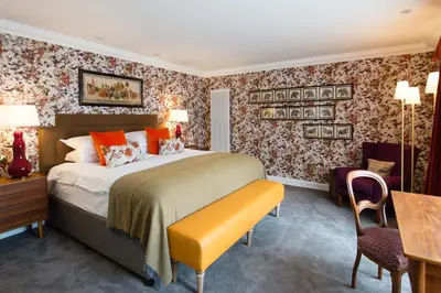 a hotel room with a bed and a desk and a chair at One Devonshire Gardens a Hotel Du Vin in Glasgow