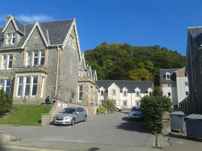 a house with two cars parked in front of it at Oban Youth Hostel in Oban