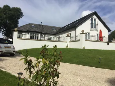 a white house with a car parked in front of it at Retreat at The Knowe Auchincruive Estate in Ayr