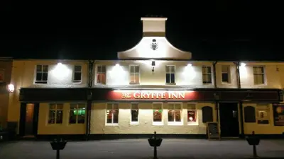 a building with a sign that reads the garage inn at night at The Gryffe Inn in Bridge of Weir
