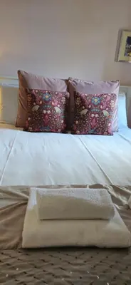 a white bed with pillows and a blanket on it at Dean Village Cottage in Edinburgh