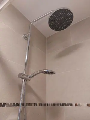 a shower with a shower head in a bathroom at Dean Village Cottage in Edinburgh