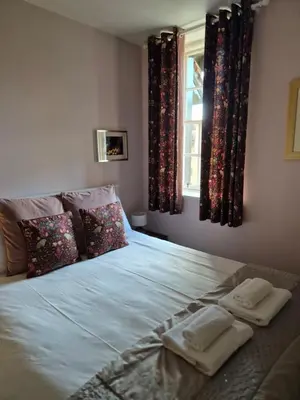 a bedroom with a bed with pillows and a window at Dean Village Cottage in Edinburgh