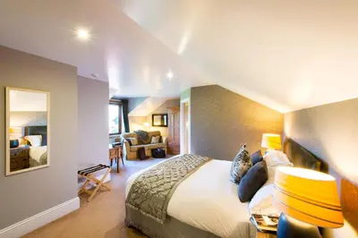 a bedroom with a bed and a living room at Knockderry Country House Hotel in Cove