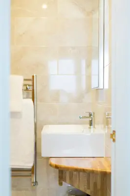 a bathroom with a white sink and a mirror at Knockderry Country House Hotel in Cove