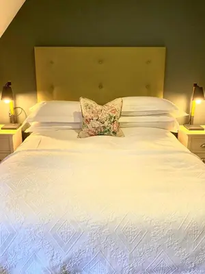 a white bed with a pillow on top of it at Knockderry Country House Hotel in Cove