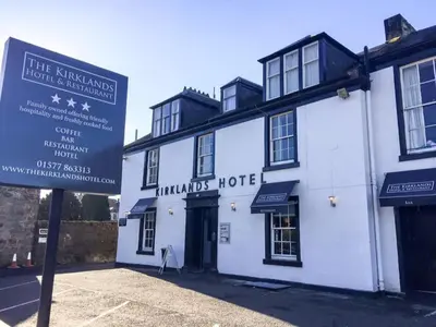 a white building with a sign in front of it at Kirklands Hotel in Kinross