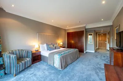 a hotel room with a bed and a chair at Sherbrooke Castle Hotel in Glasgow