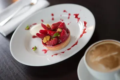 a white plate with a dessert and a cup of coffee at Sherbrooke Castle Hotel in Glasgow