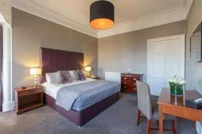 a hotel room with a bed and a desk and a desk at Sherbrooke Castle Hotel in Glasgow