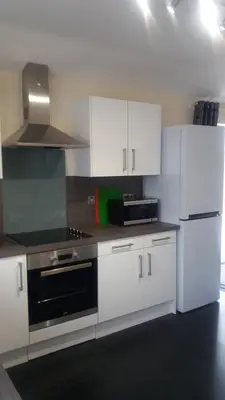 a kitchen with white cabinets and a stove top oven at Ritchie selfcatering in Callander