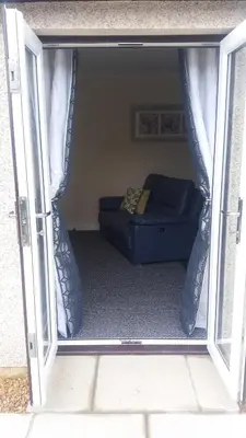a living room with a couch through a door at Ritchie selfcatering in Callander