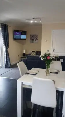 a living room with a white table and white chairs at Ritchie selfcatering in Callander