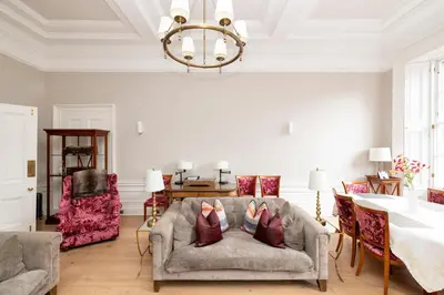 a living room with a couch and a chandelier at JOIVY Ultra Luxe Home near Princes Street in Edinburgh