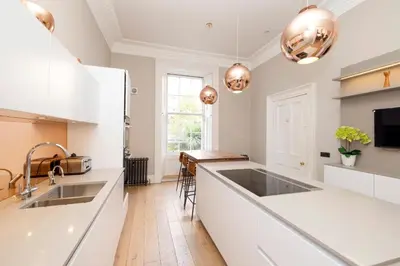 a kitchen with white countertops and a sink at JOIVY Ultra Luxe Home near Princes Street in Edinburgh