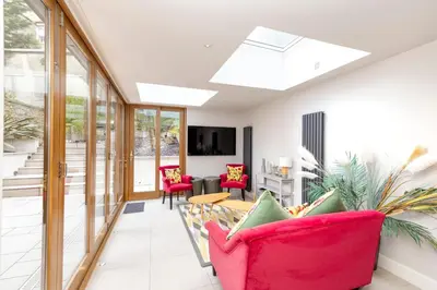 a living room with a pink couch and chairs at JOIVY Ultra Luxe Home near Princes Street in Edinburgh
