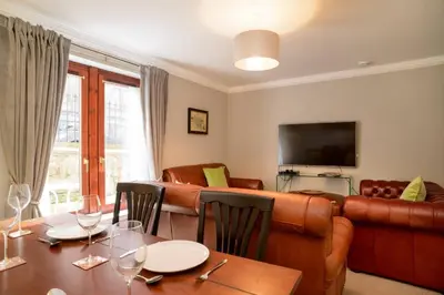 a living room with a table and a couch at JOIVY Gorgeous Flat near The Scotland Gallery in Edinburgh