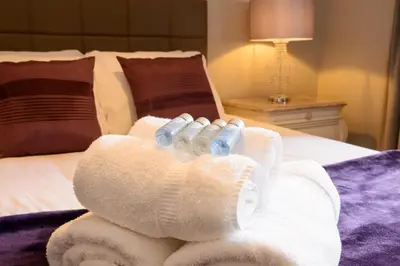 a pair of rolled up towels on a bed at JOIVY Gorgeous Flat near The Scotland Gallery in Edinburgh