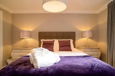 a bedroom with a purple bed with towels on it at JOIVY Gorgeous Flat near The Scotland Gallery in Edinburgh