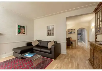 a living room with a couch and a table at JOIVY Boutique Apt with Patio in New Town in Edinburgh