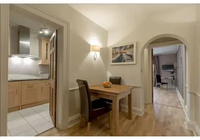 a kitchen and dining room with a wooden table at JOIVY Boutique Apt with Patio in New Town in Edinburgh