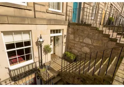 a staircase leading to a building with a white door at JOIVY Boutique Apt with Patio in New Town in Edinburgh