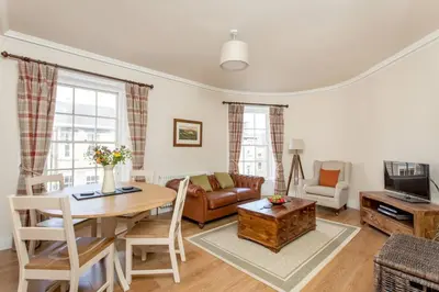 a living room with a table and a couch at JOIVY Stylish Apt in Trendy New Town Location in Edinburgh