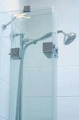 a shower with a glass door and a shower head at JOIVY Stylish Apt in Trendy New Town Location in Edinburgh