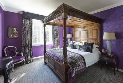 a bedroom with a canopy bed and purple walls at JOIVY Charming Nest for Two with Castle View in Edinburgh