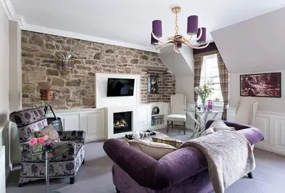 a living room with a purple couch and a fireplace at JOIVY Charming Nest for Two with Castle View in Edinburgh