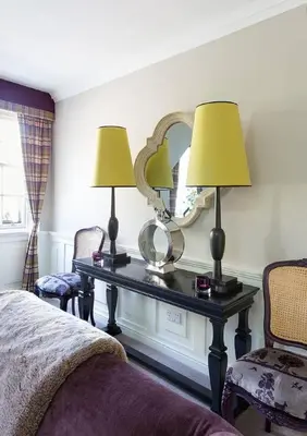 a bedroom with a table with two lamps and a mirror at JOIVY Charming Nest for Two with Castle View in Edinburgh