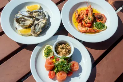 four plates of food on a table with seafood at Holly Tree Hotel, Swimming Pool & Hot Tub in Glencoe